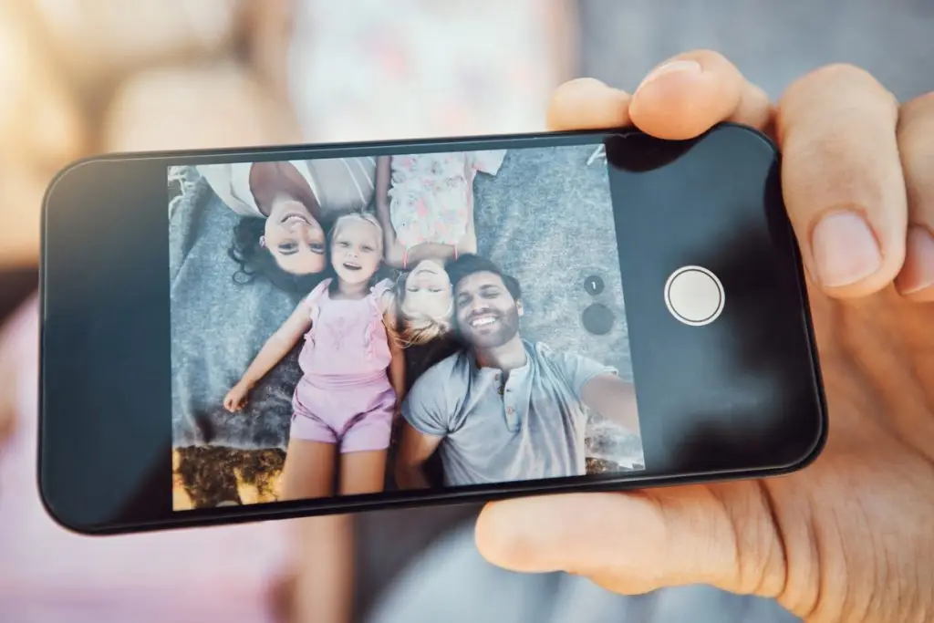 Smartphone showing a family taking a photo together, representing digital assets in estate planning.